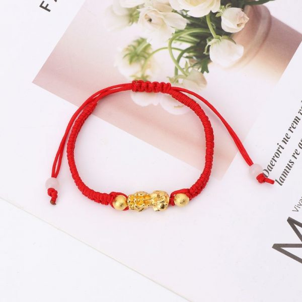 A stylish red string bracelet with elegant gold accents, combining prosperity and positive energy.